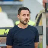 Roberto De Zerbi, mit seinem charakteristischen Blick, steht im Stadion. Seine bisherigen Trainerstationen prägen seine Laufbahn.