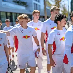 Junge Fußballer des RB Leipzig U12 Teams in weißen Trikots mit dem Bullen-Logo gehen gemeinsam.