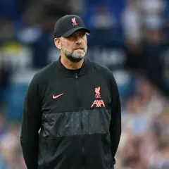 Trainer Klopp, mit Bart und Kappe, blickt nachdenklich. Er trägt eine schwarze Jacke mit dem Liverpool-Logo.
