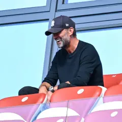 Jürgen Klopp, mit einer New York Yankees Kappe, lacht auf der Tribüne. Vielleicht beobachtet er ein Spiel des DFB.