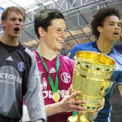 Drei junge Schalker Spieler mit Pokal. Links ein Torwart, Mitte ein Mittelfeldspieler mit Medaille, rechts ein Angreifer.