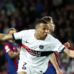 Kylian Mbappé feiert einen seiner vielen Tore, jubelnd im weißen PSG-Trikot.