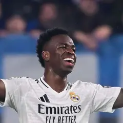 Vinícius Júnior jubelt ausgelassen im weißen Trikot von Real Madrid, die Arme erhoben.
