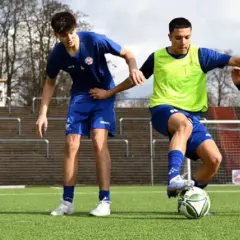 Vier junge Fußballer im C-Jugend-Training üben auf dem Kunstrasen. Einer dribbelt den Ball, die anderen verteidigen.