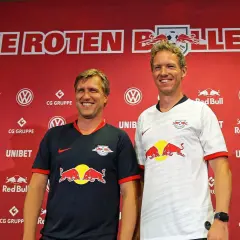 Julian Nagelsmann und ein Kollege posieren vor der roten Kulisse von RB Leipzig.