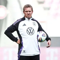 Der Deutschland Trainer Julian Nagelsmann hält einen Fußball.