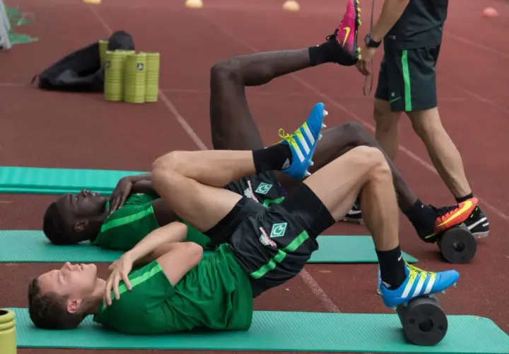 Fußballer trainieren auf Rollen für propriozeptives Training Sprunggelenk.