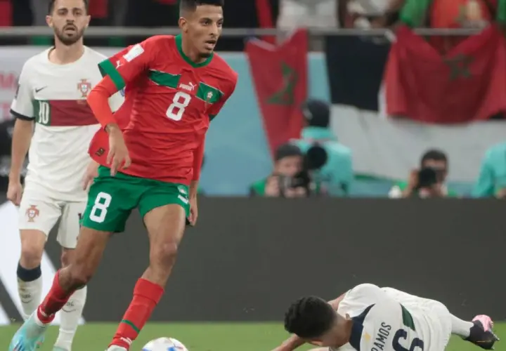 Azzedine Ounahi im roten Trikot mit der Nummer 8 dribbelt, während ein portugiesischer Spieler im Hintergrund steht.