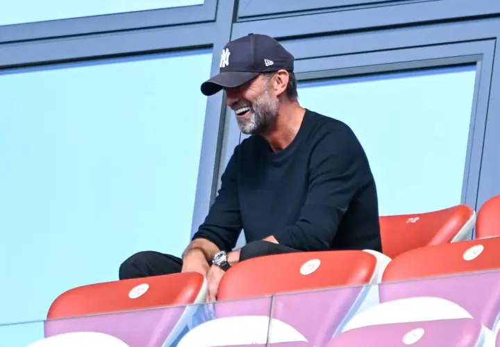 Jürgen Klopp, mit einer New York Yankees Kappe, lacht auf der Tribüne. Vielleicht beobachtet er ein Spiel des DFB.