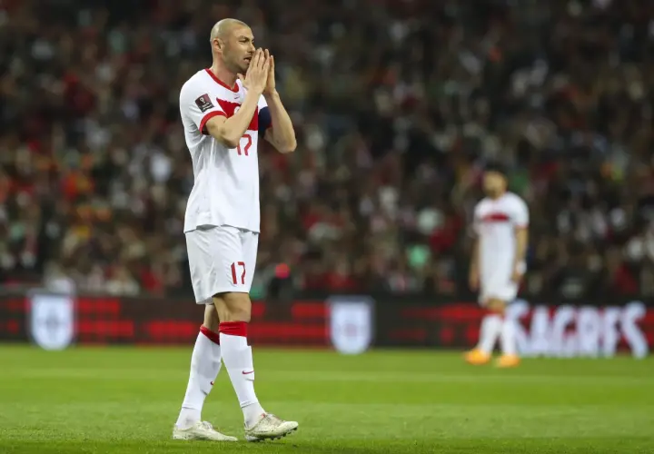 Burak Yılmaz, mit gefalteten Händen, blickt nachdenklich auf das Spielfeld.