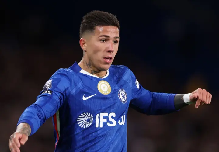 Enzo Fernández im blauen Chelsea-Trikot, mit Tätowierungen am Hals und Arm, bereit für das Spiel.