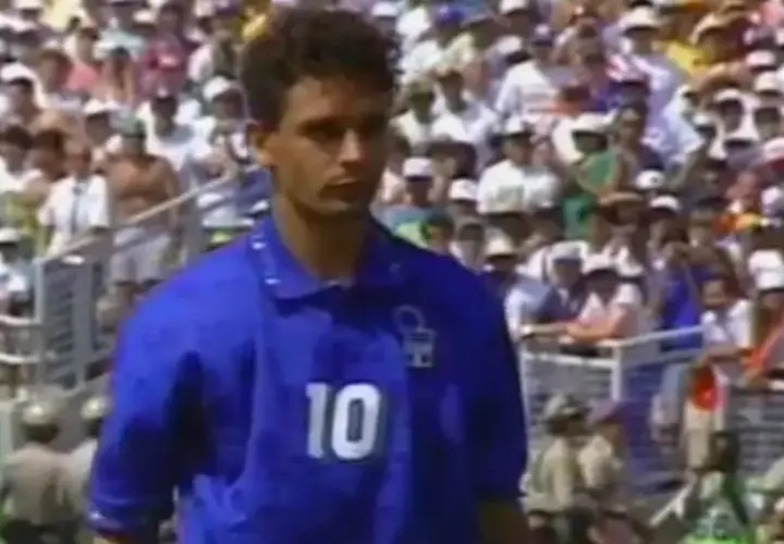 Fußballlegende Roberto Baggio im blauen Trikot mit der Nummer 10, vor jubelnden Fans im Stadion.