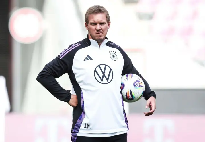 Der Deutschland Trainer Julian Nagelsmann hält einen Fußball.