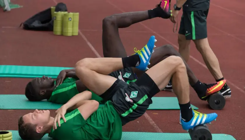 Fußballer trainieren auf Rollen für propriozeptives Training Sprunggelenk.