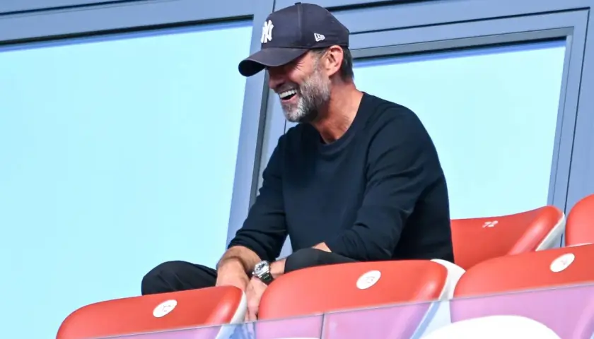 Jürgen Klopp, mit einer New York Yankees Kappe, lacht auf der Tribüne. Vielleicht beobachtet er ein Spiel des DFB.