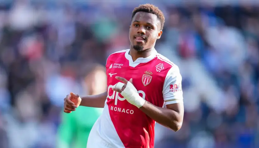 Fußballer Ansu Fati im Monaco-Trikot, mit Bandagen am Arm, blickt nach rechts und zeigt auf etwas.