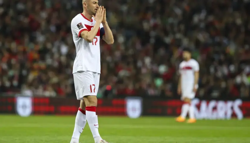 Burak Yılmaz, mit gefalteten Händen, blickt nachdenklich auf das Spielfeld.