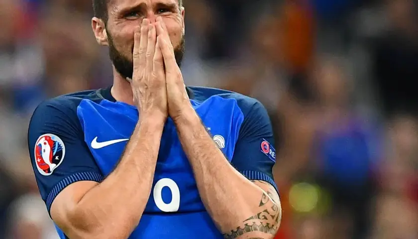Olivier Giroud hält sich verzweifelt die Hände vors Gesicht, seine Augen sind geschlossen.