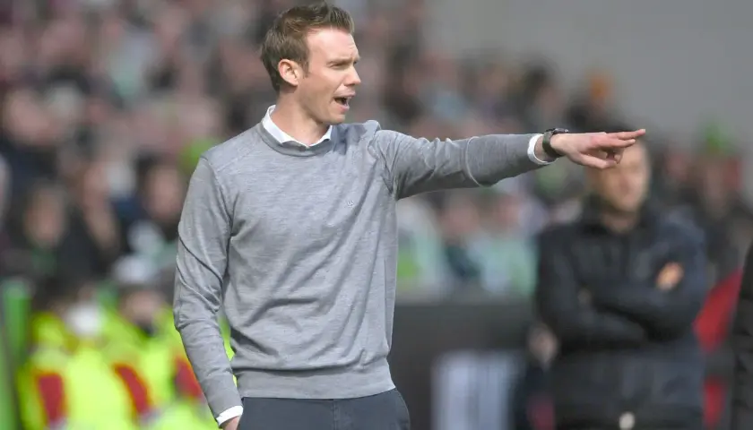 Tommy Stroot gibt Anweisungen am Spielfeldrand, sein Zeigefinger weist in die Ferne.