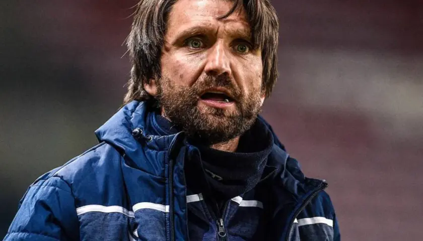 Peter Hyballa, Trainer, mit Bart und wachem Blick, trägt eine blaue Jacke.