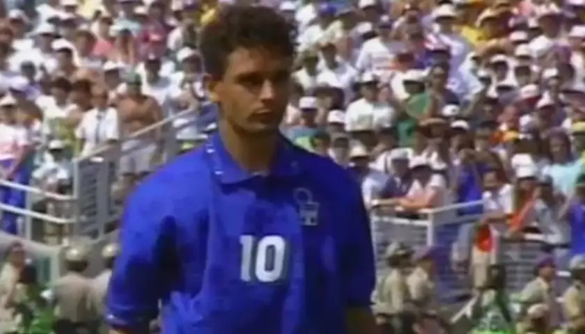 Fußballlegende Roberto Baggio im blauen Trikot mit der Nummer 10, vor jubelnden Fans im Stadion.