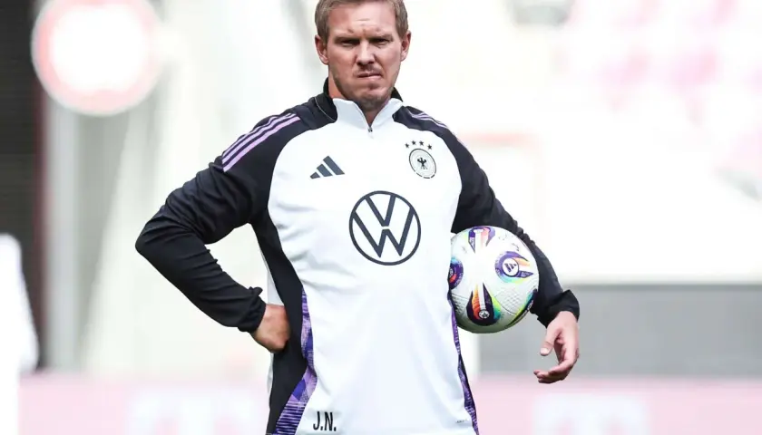 Der Deutschland Trainer Julian Nagelsmann hält einen Fußball.