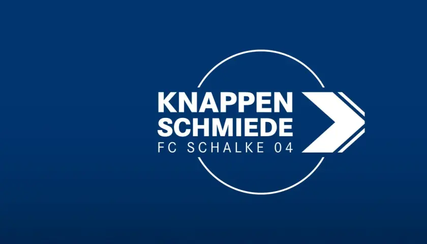 Das Logo der "Knappenschmiede FC Schalke 04" auf blauem Hintergrund. Hier werden die Talente für die Schalke U15 und darüber hinaus geformt.
