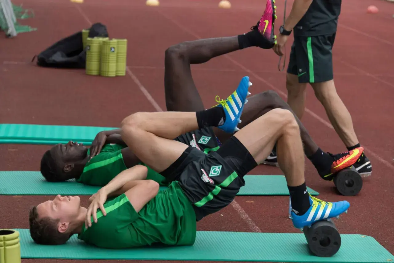 Fußballer trainieren auf Rollen für propriozeptives Training Sprunggelenk.