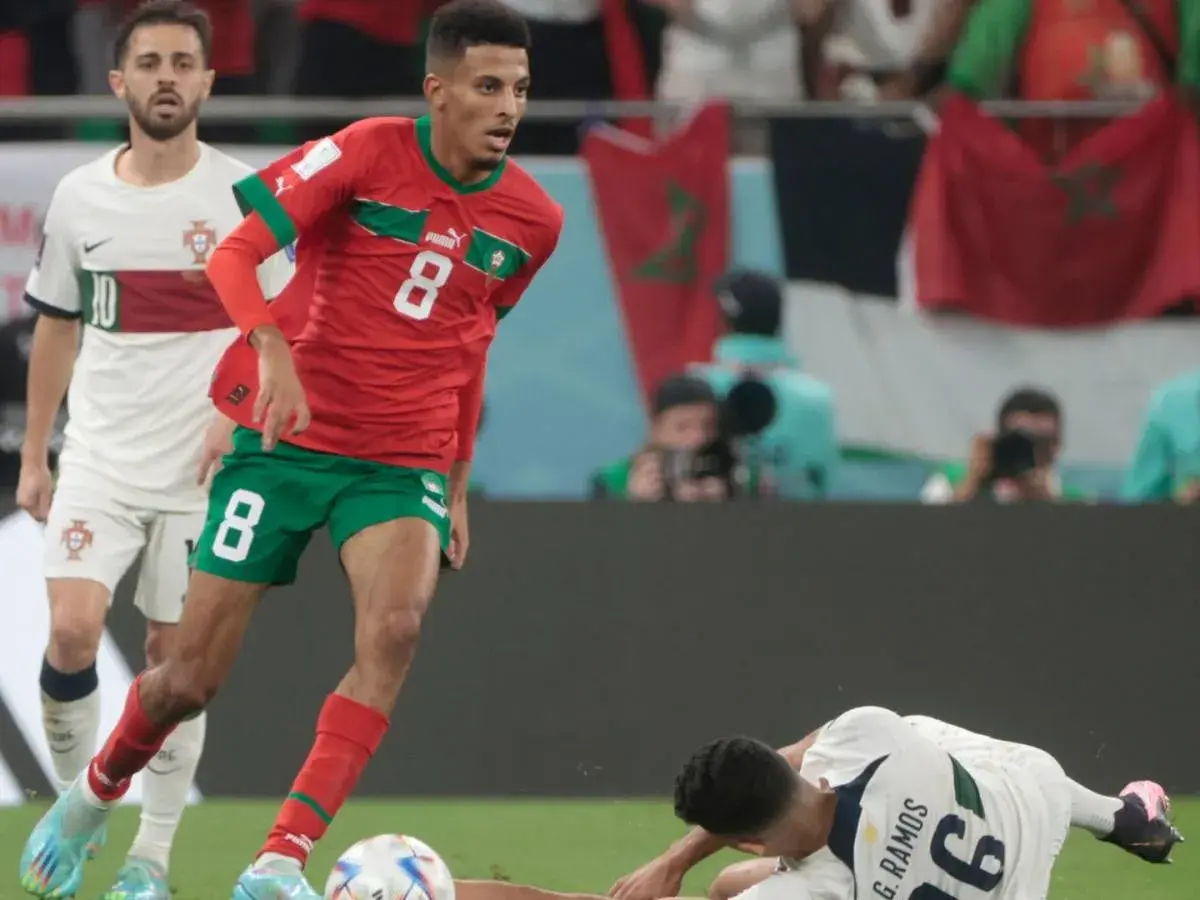 Azzedine Ounahi im roten Trikot mit der Nummer 8 dribbelt, während ein portugiesischer Spieler im Hintergrund steht.