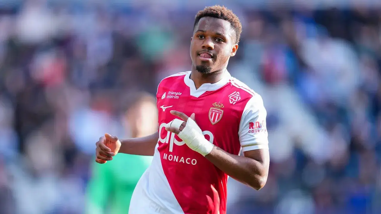 Fußballer Ansu Fati im Monaco-Trikot, mit Bandagen am Arm, blickt nach rechts und zeigt auf etwas.