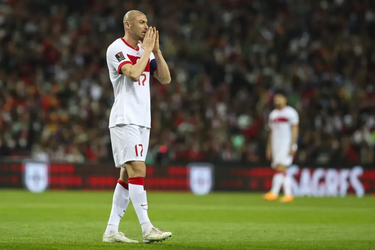 Burak Yılmaz, mit gefalteten Händen, blickt nachdenklich auf das Spielfeld.