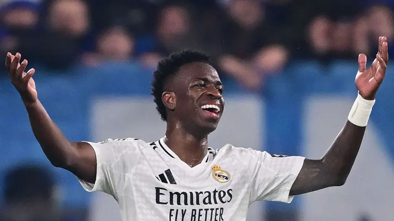 Vinícius Júnior jubelt ausgelassen im weißen Trikot von Real Madrid, die Arme erhoben.