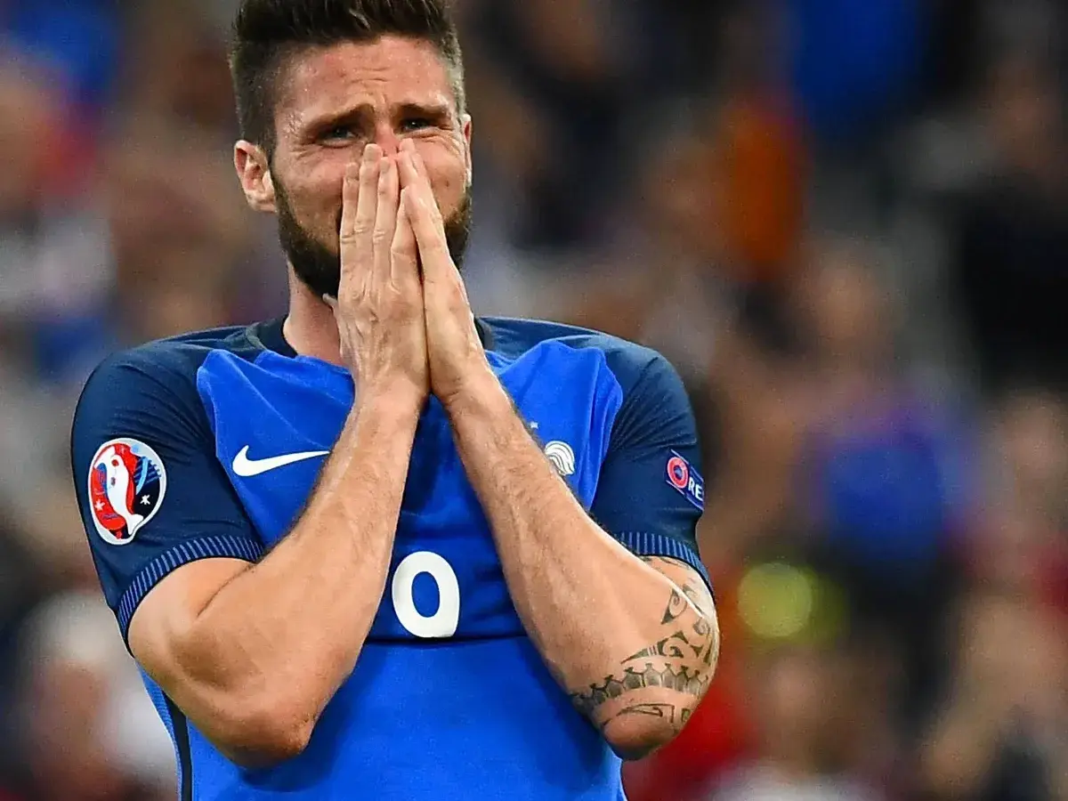 Olivier Giroud hält sich verzweifelt die Hände vors Gesicht, seine Augen sind geschlossen.