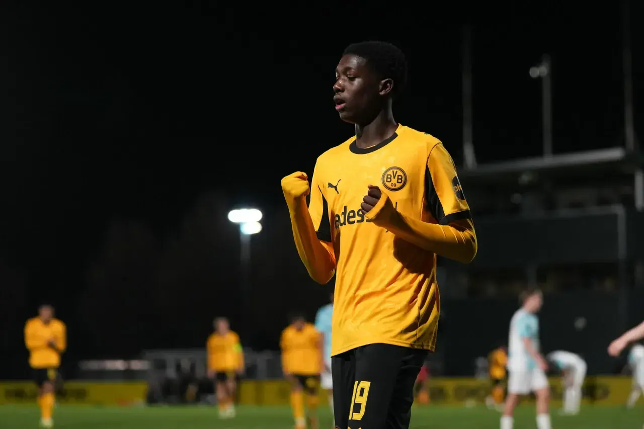 Jubelnder Spieler der BVB U14 in gelbem Trikot mit schwarzem Kragen und Ärmelbündchen.