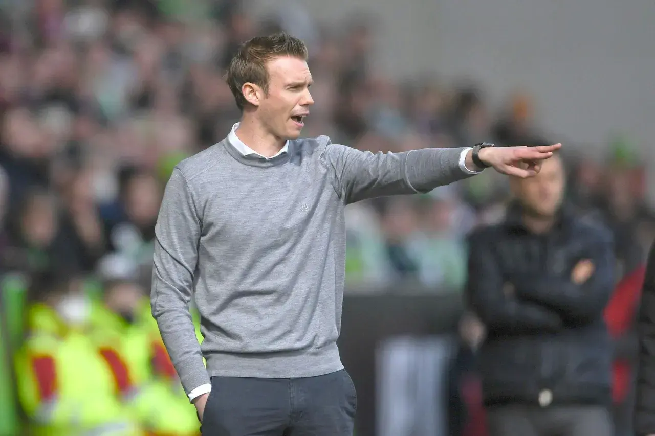 Tommy Stroot gibt Anweisungen am Spielfeldrand, sein Zeigefinger weist in die Ferne.