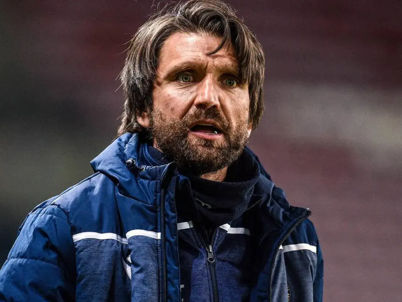 Peter Hyballa, Trainer, mit Bart und wachem Blick, trägt eine blaue Jacke.