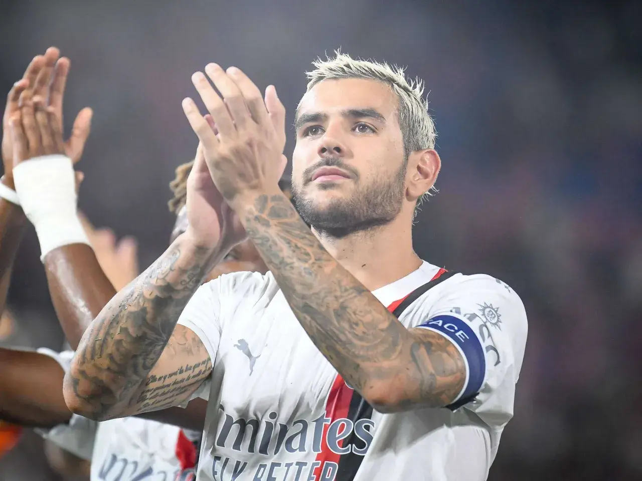 Theo Hernandez klatscht mit seinen tätowierten Armen.