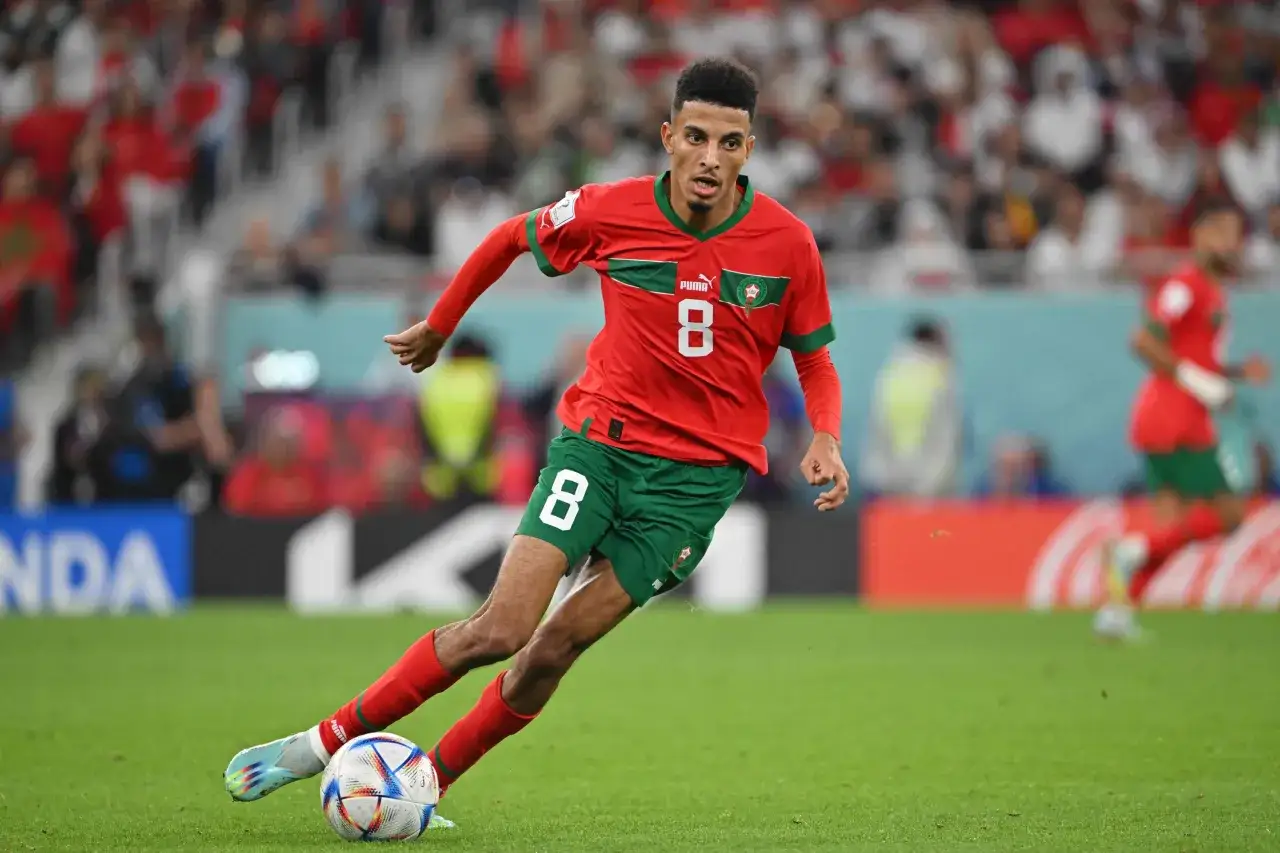 Azzedine Ounahi dribbelt mit dem Ball am Fu&szlig; &uuml;ber das Spielfeld. Er tr&auml;gt das rote Trikot mit der Nummer 8.