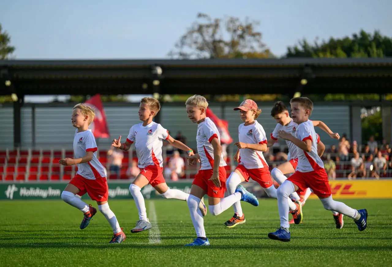 Junge Fu&szlig;baller der RB Leipzig U9 rennen auf dem Spielfeld.