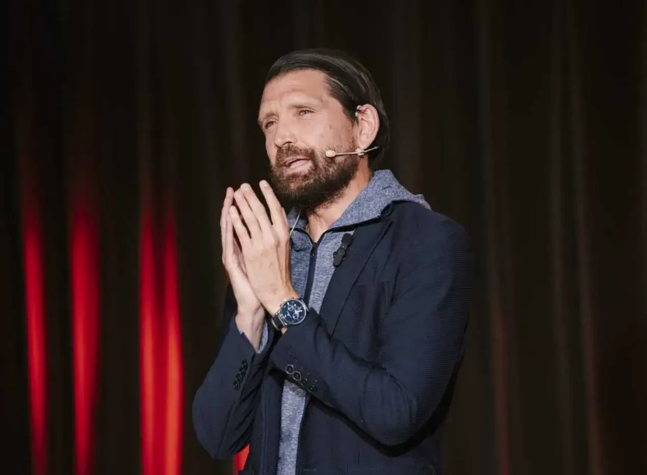 Peter Hyballa spricht mit gefalteten H&auml;nden vor einem roten Vorhang.