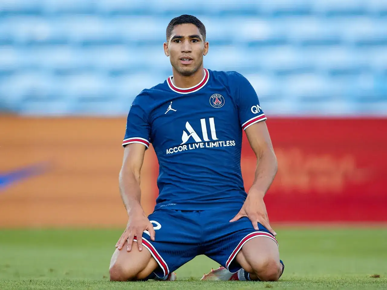 Achraf Hakimi, Spieler von Paris Saint-Germain, kniet auf dem Rasen. Seine aktuellen Teams sind PSG und die marokkanische Nationalmannschaft.