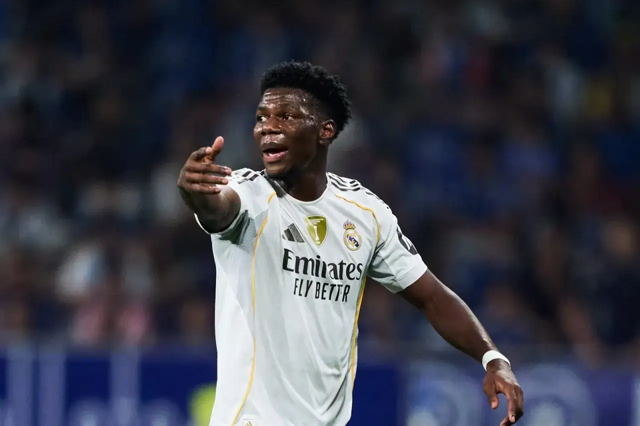 Aur&eacute;lien Tchouam&eacute;ni im wei&szlig;en Trikot von Real Madrid, zeigt auf dem Spielfeld.