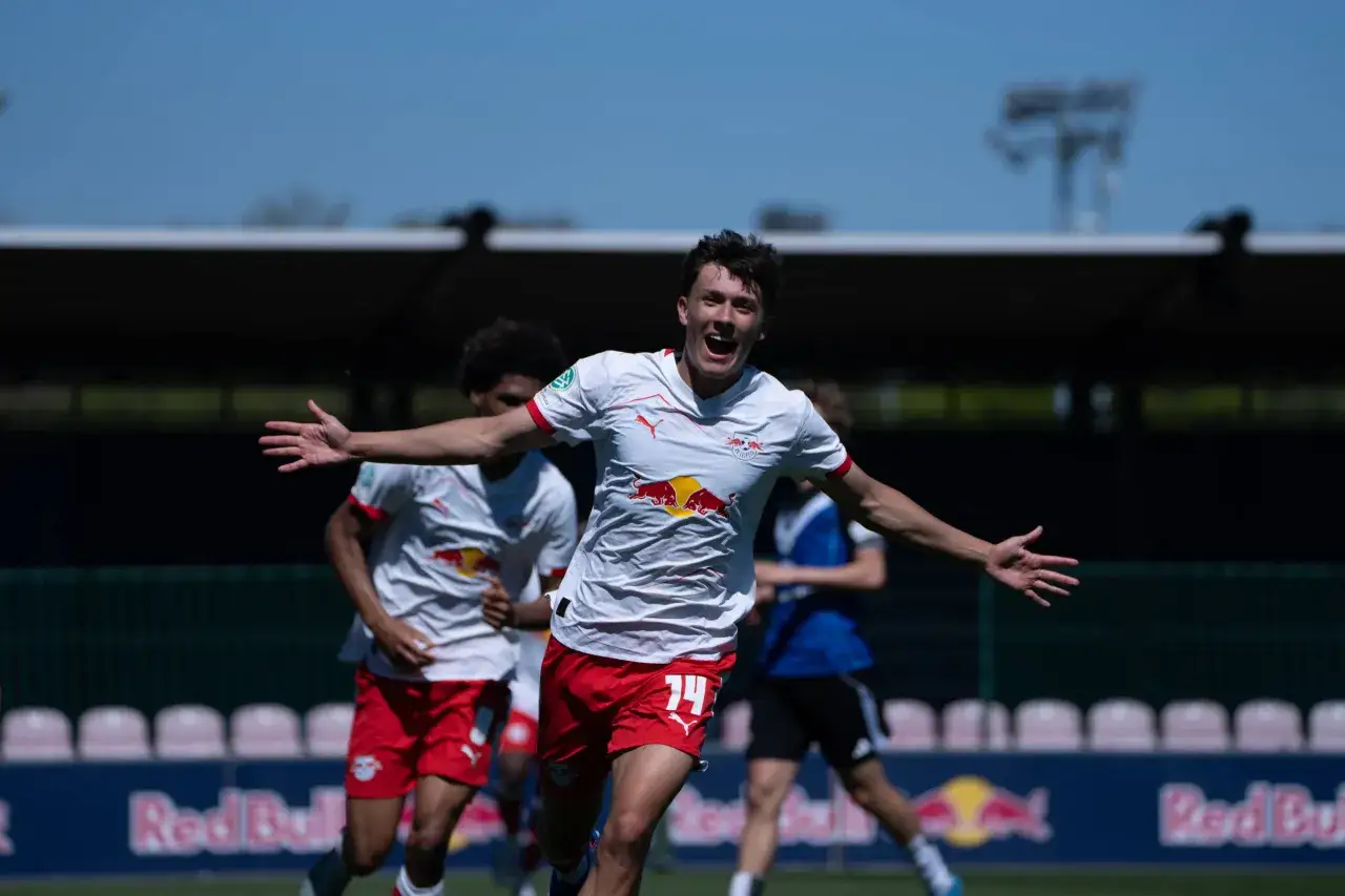 Jubelnder Spieler der RB Leipzig U12 mit ausgestreckten Armen.