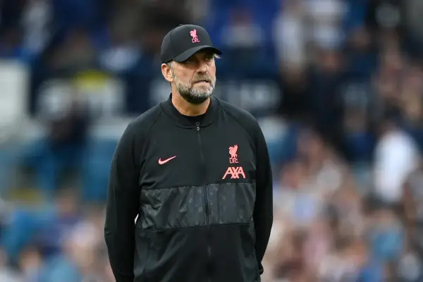Trainer Klopp, mit Bart und Kappe, blickt nachdenklich. Er trägt eine schwarze Jacke mit dem Liverpool-Logo.
