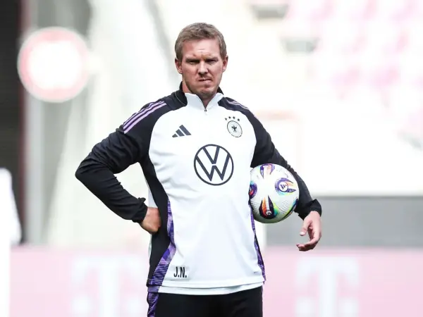 Der Deutschland Trainer Julian Nagelsmann hält einen Fußball.